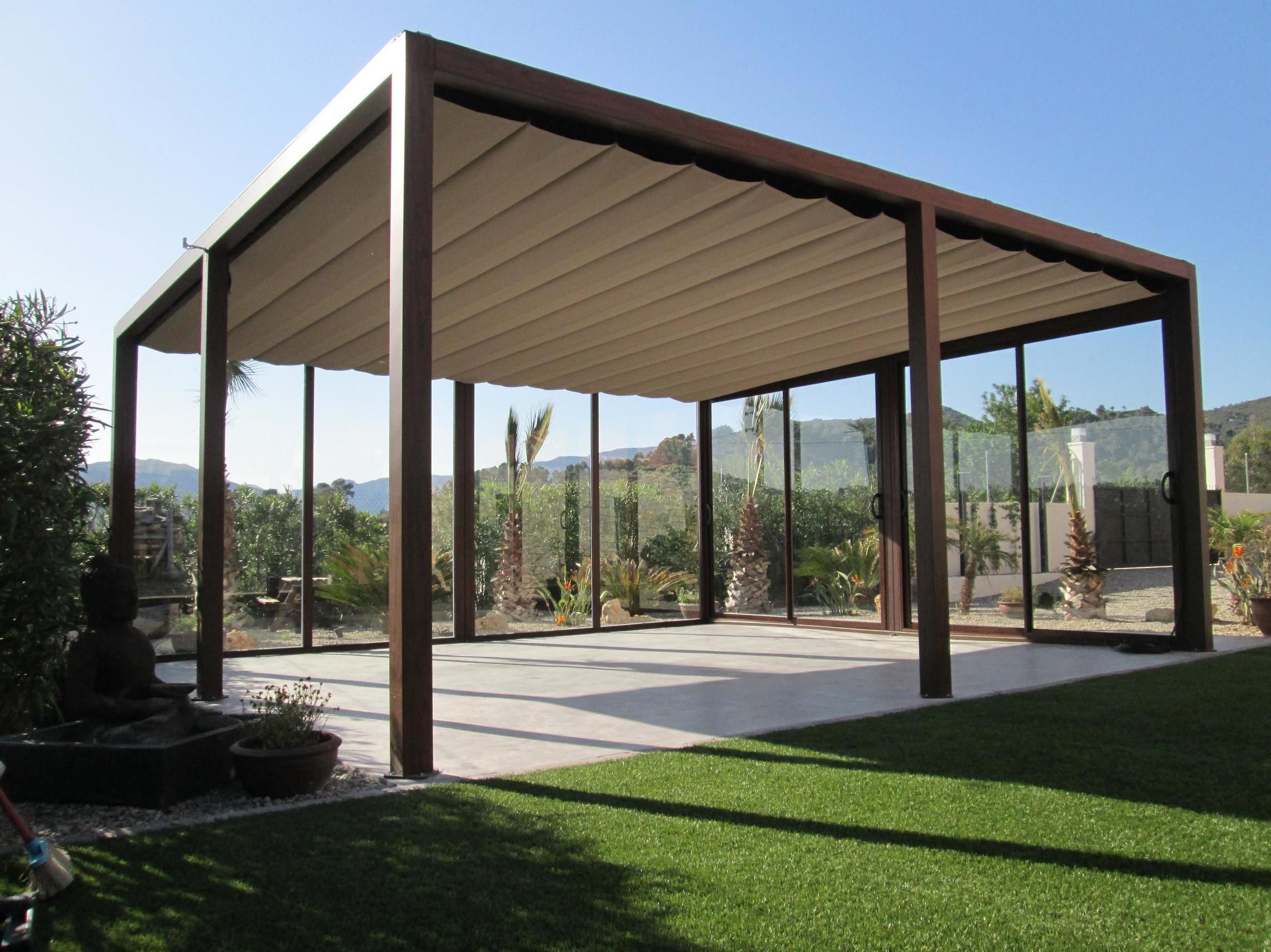 Pérgola de aluminio lacado marrón, con puerta de cristal